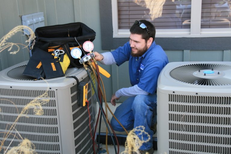 HVAC technician servicing air conditioning unit